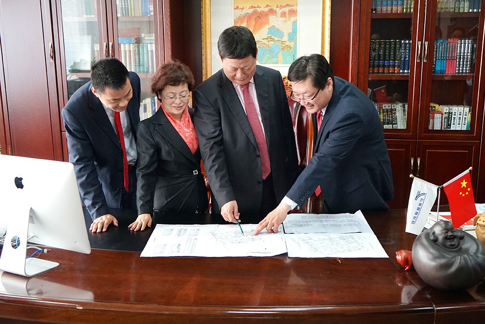 上上德盛集团董事长季学文（右二）与集团核心管理层干部在一起研究企业发展规划图.jpg